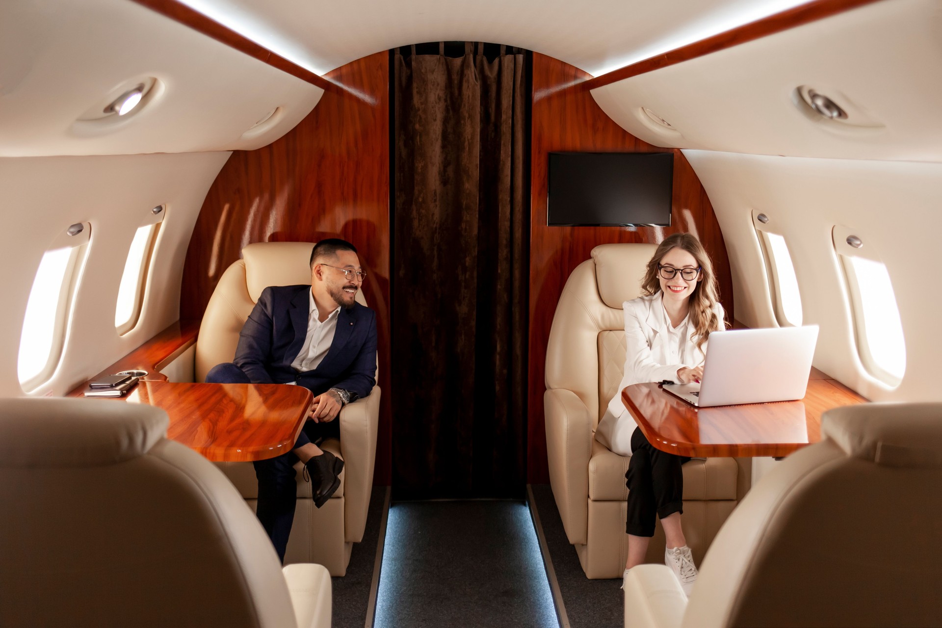 business people are flying in private luxury plane, asian businessman and woman manager are sitting in the plane