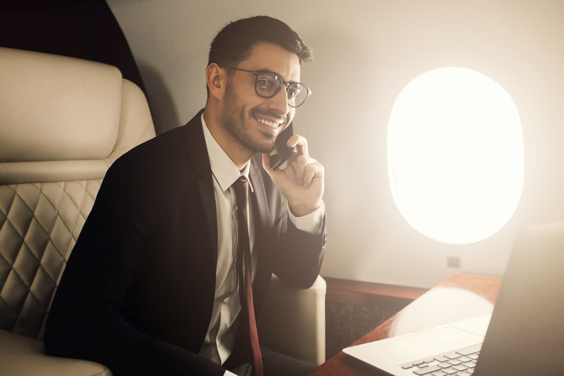 Private jet. Rich businessman or billionaire flying first class and working on plane, talking on phone